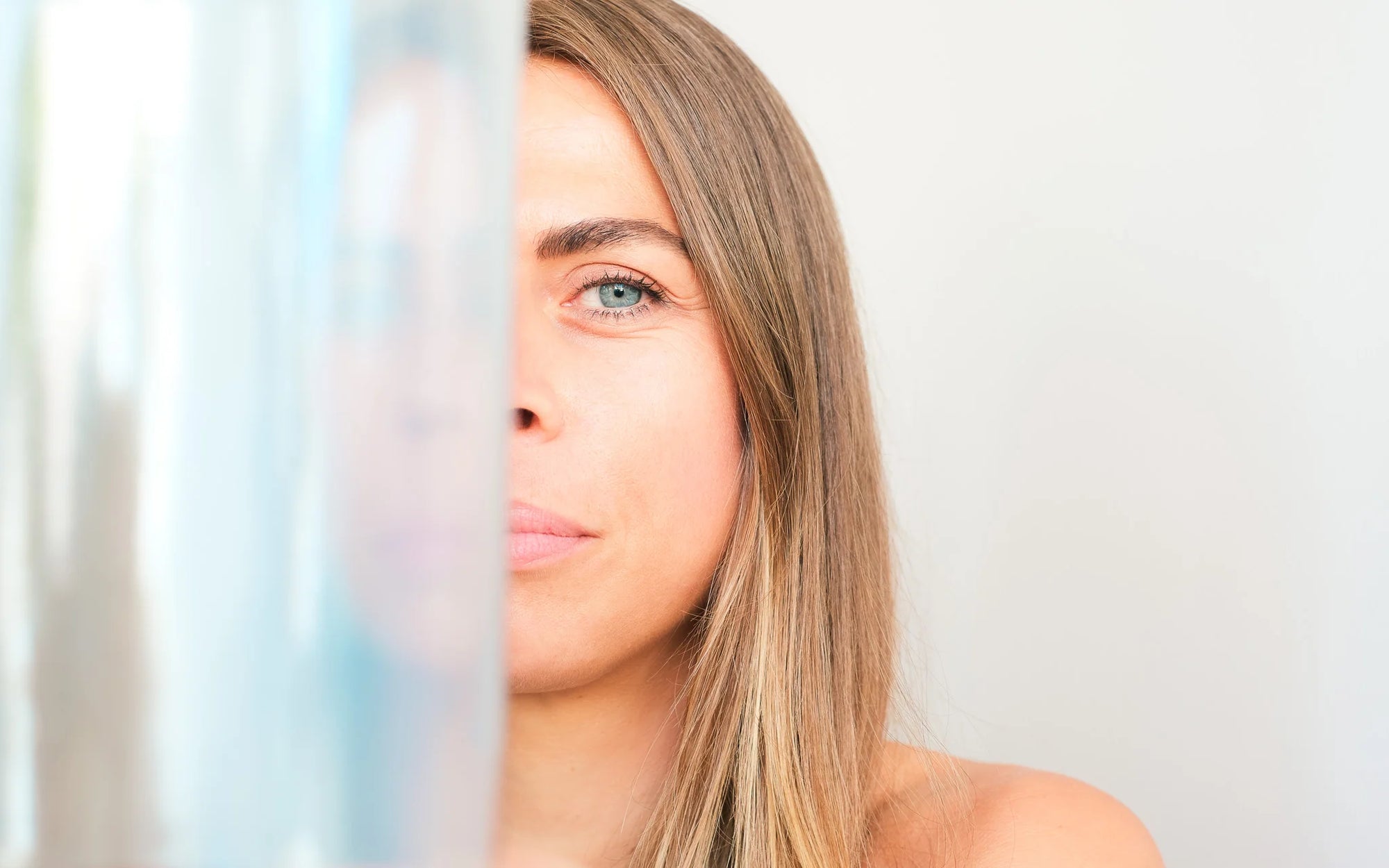 Close-up of a Lydias face partially reflected in a alchemy crystal singing bowl – bright minimal setting