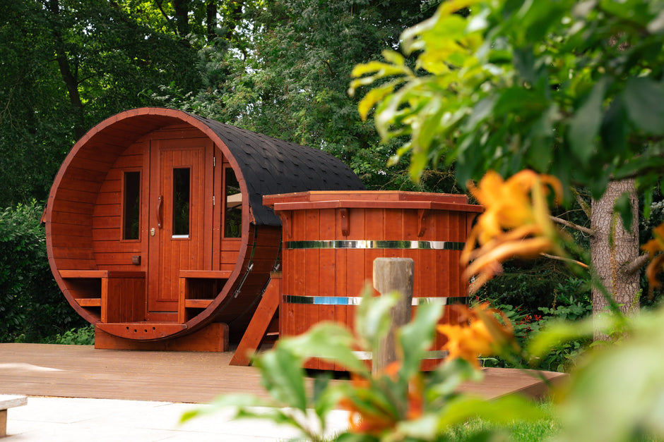 Wooden outdoor sauna and cold plunge tub surrounded by lush green nature at the retreat location